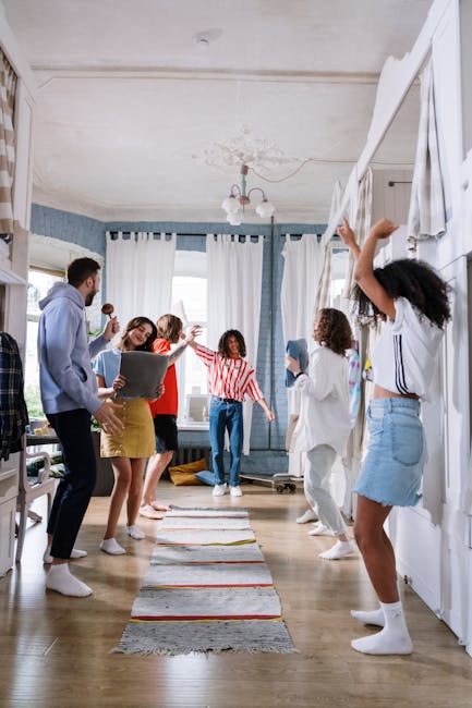 Group of young adults dancing together in a bright, modern room, enjoying a lively indoor party.